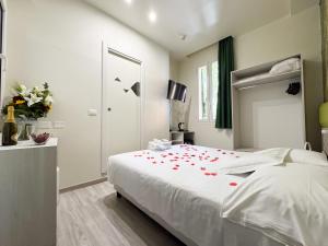 a bedroom with a bed with red rose petals on it at Hotel Giardinetto Al Sant'Orsola in Bologna
