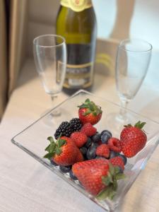 a plate of fruit on a table with wine glasses at Hotel Giardinetto Al Sant'Orsola in Bologna