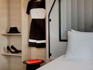 a bedroom with a bed and a dress and shoes at ibis Vichy in Vichy