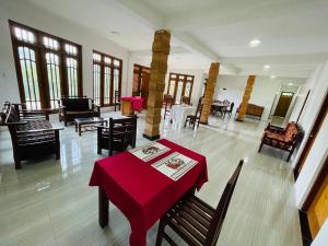 a dining room with a red table and chairs at Archwey Coco Ella in Ella