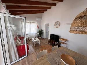 a living room with a table and a dining room at Villa Audrey in Cala en Bosc