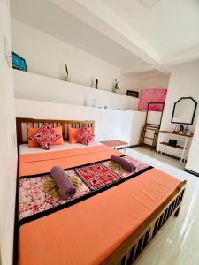 a bedroom with an orange bed in a room at Grand Infinite Home Stay in Kandy