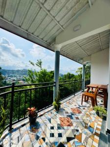 a patio with a table and chairs on a balcony at Grand Infinite Home Stay in Kandy