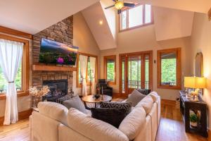 a living room with couches and a stone fireplace at Headwaters Hideaway in Elk Park