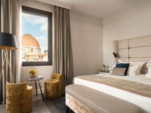 a hotel room with a large bed and a window at Cerretani Hotel Firenze - MGallery Collection in Florence +135 photos