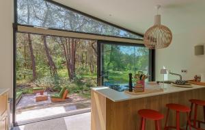 a kitchen with a large window with a view of the woods at De Rode Vos - Enjoyment in the forest in Giethmen