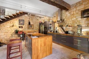 a large kitchen with a stone wall at La Maison de Marie in Domme