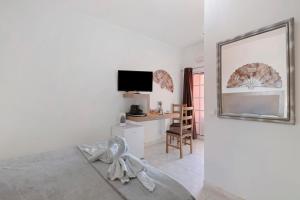 a bedroom with a bed and a desk with a television at South Star Guesthouse in Quelfes