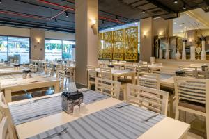 a restaurant with white tables and chairs and windows at Miarosa İncekum Beach in Avsallar