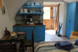 a kitchen with blue cabinets and a table in a room at Apartments Skok in Bled