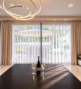 two glasses of wine on a table with a chandelier at Casa di Jiovanni Luxury in Asgourou