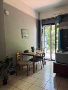 a dining room with a table and chairs and a television at Magklaras Seaside Apartments in Néa Palátia