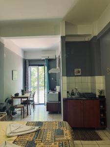 a room with a kitchen and a dining room with a table at Magklaras Seaside Apartments in Néa Palátia +9 photos