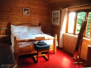 a bedroom with a bed in a log cabin at ballyskelly lodge in Jemimaville