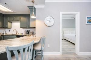 a kitchen with green cabinets and a clock on the wall at Phoenix VII 71106 condo in Orange Beach