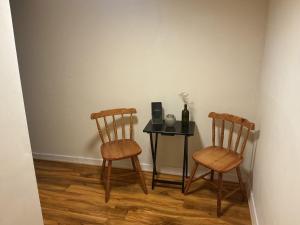 zwei Stühle und ein Tisch mit einer Flasche Wein in der Unterkunft Barn 5 in Vigo Village