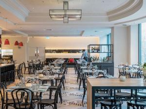 a dining room filled with tables and chairs at Novotel Melbourne On Collins in Melbourne
