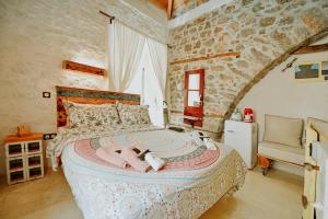 a bedroom with a large bed in a stone wall at Mastoris Mansion in Hydra +94 photos