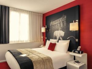 a hotel room with a bed with a black and red wall at Mercure Paris Opera Louvre in Paris