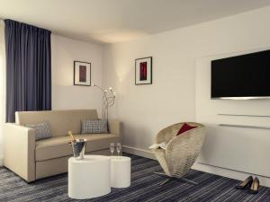 a living room with a couch and a chair at Mercure Paris Opera Louvre in Paris +63 photos