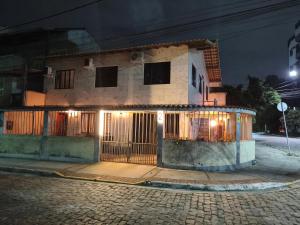 a house with a gate on a street at night at Hostel Dunas & Mar - Hostel e Suítes - Cabo Frio in Cabo Frio +45 photos