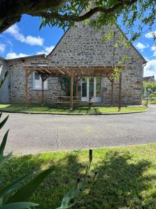 a stone building with a pavilion in front of it at Gîte L'Instant Présent in Messeix +14 photos