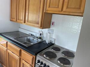 a kitchen with a sink and a stove at Padraig cottage in Gortatlea +10 photos