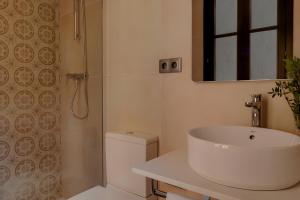 a white bathroom with a sink and a shower at Hotel Hamsa House in Barcelona