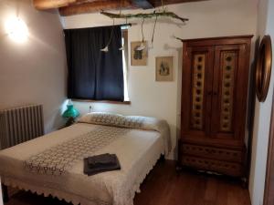 a bedroom with a bed and a wooden cabinet at Ca' Merla affittacamere in Morbegno