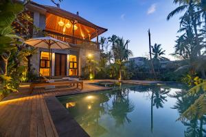 a villa with a pool in front of a house at The Dura Ubud in Ubud