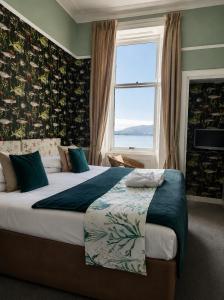 a bedroom with a large bed with a window at The Ardyne Guest House in Rothesay