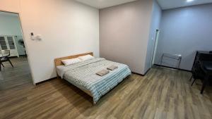 a bedroom with a bed with two towels on it at Homestay House - Tamparuli in Tamparuli