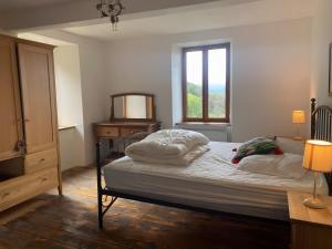 a bedroom with a bed with a dresser and a window at Maison De Fontale in Aleu