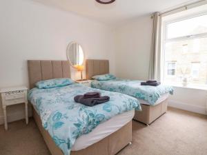 a bedroom with two beds and a mirror and a window at 163 Manchester Road in Accrington