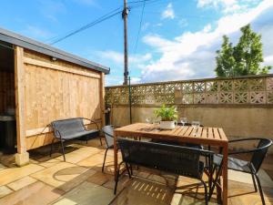 a patio with a wooden table and chairs at 163 Manchester Road in Accrington