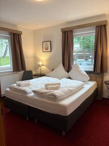 a bedroom with a bed with white sheets and pillows at Chalet Rotenstein in Berwang