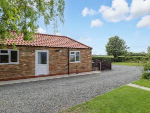 a small brick house with a gravel driveway at The New Build in Louth