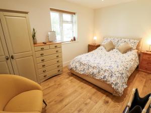 a bedroom with a bed and a dresser and a window at The New Build in Louth
