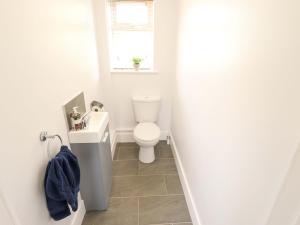 a white bathroom with a toilet and a window at The New Build in Louth +16 photos