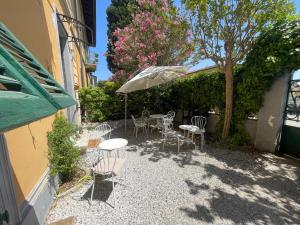 a patio with tables and chairs and an umbrella at Le Cascine in Pisa