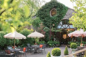 an outdoor patio with tables and chairs and umbrellas at The Station House Hotel in Kilmessan