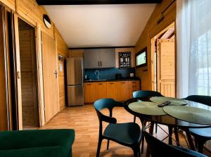 a dining room with tables and chairs and a kitchen at Domek na Orlej in Giewartów