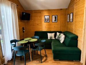 a living room with a green couch and a table at Domek na Orlej in Giewartów