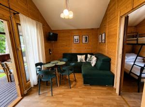 a living room with a couch and a table and chairs at Domek na Orlej in Giewartów