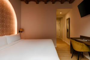 a bedroom with a large bed and a desk at Hotel Hamsa House in Barcelona