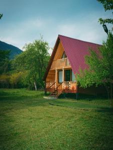 a large wooden house with a red roof at Lakarido in Tsesi