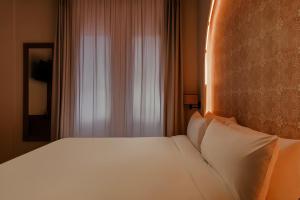 a bedroom with a white bed and a window at Hotel Hamsa House in Barcelona