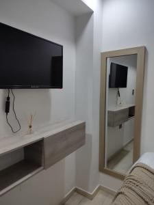 a living room with a tv and a mirror at Hotel Aquamarina Maicao in Maicao
