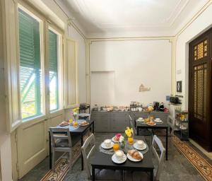a room with two tables and chairs with food on them at Le Cascine in Pisa