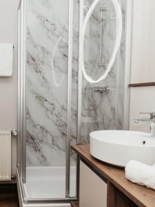 a bathroom with a shower and a sink at Hotel Villa Rainer in Pörtschach am Wörthersee +90 photos